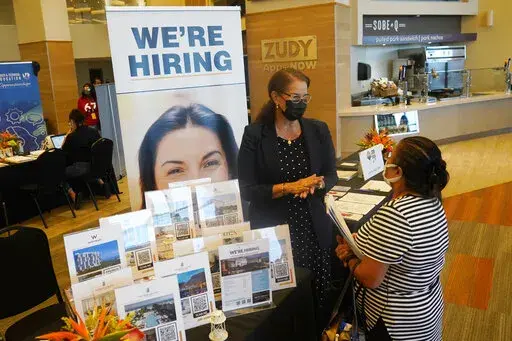 Marriott human resources recruiter Mariela Cuevas, left, talks to Lisbet Oliveros, during a job fair at Hard Rock Stadium, Friday, Sept. 3, 2021, in Miami Gardens, Fla.  Last month, U.S. employers might have shed jobs for the first time in about a year, potentially raising alarms about the economy’s trajectory. Yet even if the January employment report coming Friday, Feb. 3, 2022, were to show a deep loss of jobs, there would be little mystery about the likely culprit: A wave of omicron wave o