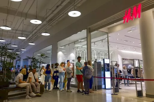 People line up to enter an H&M shop and buy items on sale in the Aviapark shopping mall in Moscow, Russia, Tuesday, Aug. 9, 2022. Russians are snapping up Western fashion and furniture this week as H&M and IKEA sell off the last of their inventory in Russia, moving forward with their exit from the country after it sent troops into Ukraine. Sweden-based H&M and Netherlands-based IKEA had paused sales in Russia after the military operation began and are now looking to unload their stocks of clothi
