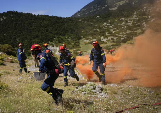 Firefighters of the 1st Wildfire Special Operation Unit, take part in a drill near Villia village some 60 kilometers (37 miles) northwest of Athens, Greece, Friday, April 19, 2024. Greece's fire season officially starts on May 1 but dozens of fires have already been put out over the past month after temperatures began hitting 30 degrees Celsius (86 degrees Fahrenheit) in late March. This year, Greece is doubling the number of firefighters in specialized units to some 1,300, adopting tactics from