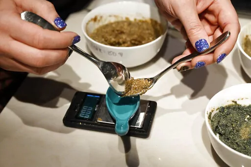 Rabbi Ben Gorelick, measures out a precise amount Sacrament, psilocybin mushrooms, during Sacred Tribe Sacrament ceremony at the Synagogue, his home, on Nov. 6, 2021, in Denver. Colorado voters are deciding whether theirs will be the second state, after Oregon, to decriminalize psychedelic mushrooms for those 21 and older. A ballot measure would create state-regulated "healing centers" for patients to experience the drug. (Andy Cross/The Denver Post via AP, File)