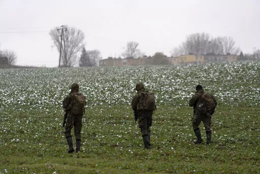 Polish soldiers search for missile wreckage in the field, near the place where a missile struck, in a farmland at the Polish village of Przewodow, near the border with Ukraine, Thursday, Nov. 17, 2022. (AP Photo/Vasilisa Stepanenko)