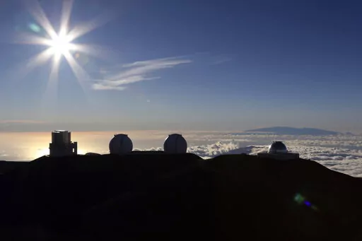 The sun sets behind telescopes on July 14, 2019, at the summit of the Big Island's Mauna Kea in Hawaii. For over 50 years, telescopes have dominated the summit of Mauna Kea, a place sacred to Native Hawaiians and one of the best places in the world to study the night sky. That's now changing with a new state law saying Mauna Kea must be protected for future generations and that science must be balanced with culture and the environment. (AP Photo/Caleb Jones, File)