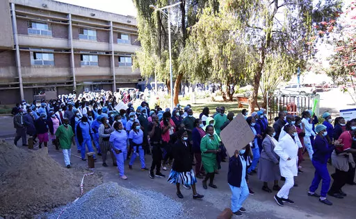 FILE -Health workers led by nurses take part in a demonstration over salaries at Parerenyatwa Hospital in Harare, on June, 21, 2022. As food costs and fuel bills soar, inflation is plundering people’s wallets, sparking a wave of protests and workers’ strikes around the world. (AP Photo/Tsvangirayi Mukwazhi)