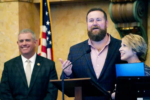 Mississippi House Speaker Philip Gunn, R-Clinton, left, laughs as "Home Town" hosts Ben Napier and Erin Napier, thank lawmakers for a House resolution honoring their HGTV home remodeling show and their work at promoting tourism in their home town of Laurel and the state, while at the Mississippi Capitol in Jackson, Tuesday, March 8, 2022. (AP Photo/Rogelio V. Solis)