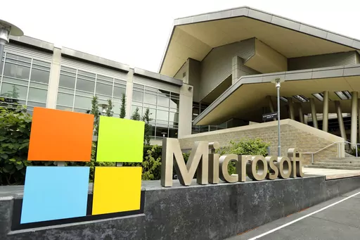 In this July 3, 2014, file photo, the Microsoft Corp. logo is displayed outside the Microsoft Visitor Center in Redmond, Wash. Microsoft is infusing generative AI tools into its Office software, including Word, Excel and Outlook emails. The company said Thursday, March 16, 2023 the new feature, named Copilot, is a processing engine that will allow users to do things like summarize long emails, draft stories in Word and animate slides in PowerPoint. (AP Photo/Ted S. Warren, File)