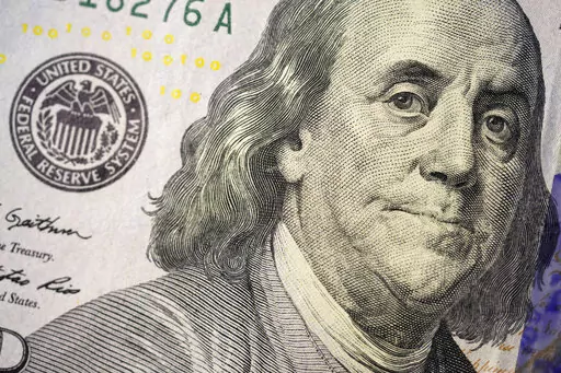 The likeness of Benjamin Franklin is seen on a U.S. $100 bill, Wednesday, Feb. 22, 2023, in Marple Township, Pa. If you are concerned you may be laid off, start saving. It's crucial to start building an emergency fund even when you feel secure at your job but especially if you think you might lose it. (AP Photo/Matt Slocum)