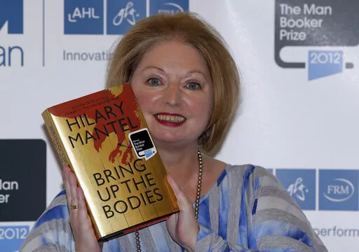 Hilary Mantel, winner of the Man Booker Prize for Fiction, poses with a copy of her book 'Bring up the Bodies', shortly after the award ceremony in central London, on Oct. 16, 2012. Mantel, the Booker Prize-winning author of the acclaimed “Wolf Hall” saga, has died, publisher HarperCollins said Friday Sept. 23, 2022. She was 70. (AP Photo/Lefteris Pitarakis, File)