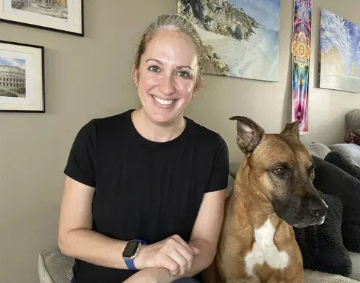 Lindsey Kee poses with her dog Teddy Ruffsavel at her home in Portland, Oregon, on Aug. 3, 2024. Kee created an exercise routine around walking her dog, (Lindsey Kee via AP)
