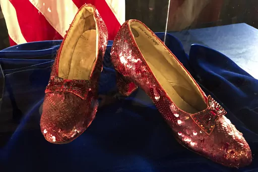 A pair of ruby slippers once worn by actress Judy Garland in the "The Wizard of Oz" sit on display at a news conference on Sept. 4, 2018, at the FBI office in Brooklyn Center, Minn. Federal prosecutors say a man has been indicted by a grand jury on Tuesday, May 16, 2023, on charges of stealing a pair of ruby red slippers worn by Judy Garland in “The Wizard of Oz.” The FBI recovered the slippers in 2018. (AP Photo/Jeff Baenen, File)