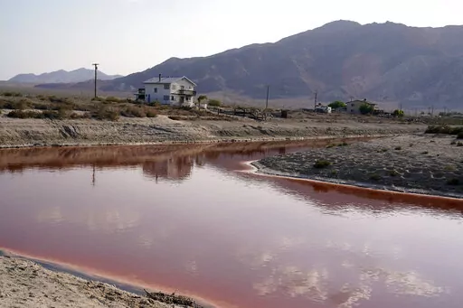 FILE— Clouds and nearby mountains are reflected in a polluted canal, once used as a boating dock, along the Salton Sea in Desert Shores, Calif., Wednesday, July 14, 2021. President Joe Biden on Tuesday, Feb. 22, 2022, pointed to plans to extract lithium from geothermal wastewater around the sea as an example of the Unites States' efforts to compete with China and other nations when it comes to domestic lithium production. The metal is a key element in rechargeable batteries, such as those used