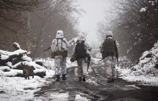 Ukrainian soldiers walks at the line of separation from pro-Russian rebels near Katerinivka, Donetsk region, Ukraine, Tuesday, Dec 7, 2021. Germany's refusal to join other NATO members in supplying Ukraine with weapons has frustrated allies and prompted some to question Berlin's resolve in standing up to Russia. (AP Photo/Andriy Dubchak)