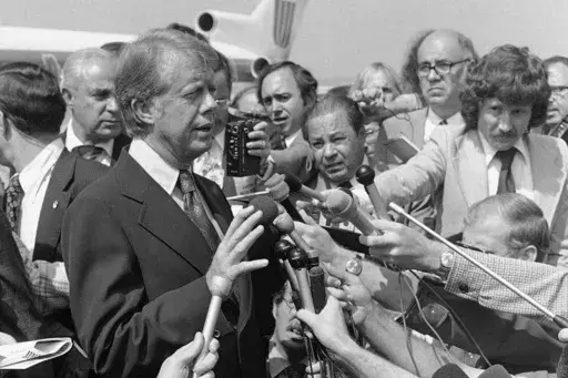 Then Democratic presidential nominee Jimmy Carter speaks to reporters on his arrival at Hobby International Airport in Houston on Sept. 24, 1976. (AP Photo/Jack Thornell, File)