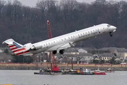 Salvage crews work on recovering wreckage near the site in the Potomac River of a mid-air collision between an American Airlines jet and a Black Hawk helicopter at Ronald Reagan Washington National Airport, Thursday, Feb. 6, 2025, in Arlington, Va. (AP Photo/Jose Luis Magana)