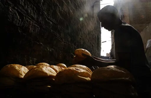 A baker stacks loaves of Egyptian traditional "baladi" flatbread outside a bakery, in the Old Cairo district of Cairo, Egypt, Sept. 8, 2022. For decades, millions of Egyptians have depended on the government to keep basic goods affordable. But a series of shocks to the global economy and Russia's invasion of Ukraine have endangered the social contract in the Middle East's most populous country, which is also the world's biggest importer of wheat. It is now grappling with double-digit inflation a