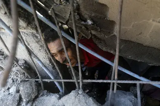 Palestinians look for survivors under the rubble of a destroyed building following an Israeli airstrike in Khan Younis refugee camp, southern Gaza Strip, Monday, Nov. 6, 2023. (AP Photo/Mohammed Dahman)