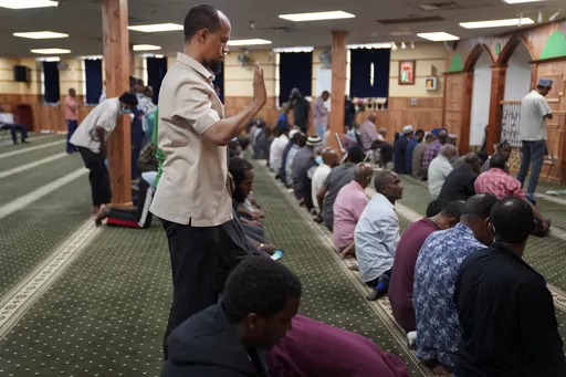 Yusuf Abdulle, standing, director of the Islamic Association of North America, prays with fellow Muslims at the Abubakar As-Saddique Islamic Center in Minneapolis on Thursday, May 12, 2022. Minneapolis will allow broadcasts of the Muslim call to prayer at all hours, Thursday, April 14, 2023, becoming the first major U.S. city to allow the announcement or “adhan” to be heard over speakers five times a day, year-round. (AP Photo/Jessie Wardarski)