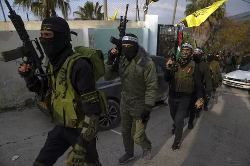 Palestinian militants take part in a military parade during a memorial ceremony commemorating their late comrades Ezzeddin Hamamrah, 24 and Amjad Khleleyah, 23, who were killed during an Israeli army raid on Jan. 14, 2023, in the West Bank village of Jaba, near Jenin, Friday, Feb. 24, 2023. Across the West Bank, small independent groups of disillusioned young Palestinians are taking up guns against Israel's open-ended occupation, defying Palestinian political leaders that they disdain as Israeli