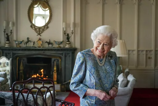Britain's Queen Elizabeth II smiles while receiving the President of Switzerland Ignazio Cassis and his wife Paola Cassis during an audience at Windsor Castle in Windsor, England, Thursday, April 28, 2022. Britain is getting ready for a party featuring mounted troops, solemn prayers — and a pack of dancing mechanical corgis. The nation will celebrate Queen Elizabeth II’s 70 years on the throne this week with four days of pomp and pageantry in central London. (Dominic Lipinski/Pool Photo via 