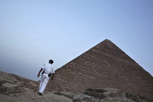 An Egyptian policeman walks near a pyramid in Giza, Egypt, on Nov. 9, 2015. A leading Egyptian opposition politician was targeted with spyware multiple times after announcing a presidential bid — including with malware that automatically infects smartphones, security researchers have found. They say Egyptian authorities were likely behind the attempted hacks. (AP Photo/Nariman El-Mofty, File)