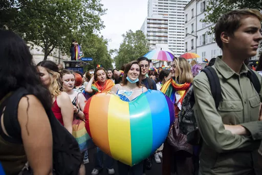 A participant holds a rainbow heart during the annual Gay Pride march in Paris, June 26, 2021. The National Assembly approved a new law unanimously Tuesday Jan. 25, 2022 evening, putting into law new measures that ban so-called conversion therapies and authorize jail time and fines for practitioners who use the scientifically discredited practice to attempt to change the sexual orientation or gender identity of LGBTQ people. The legislation includes criminal penalties for people who are convicte