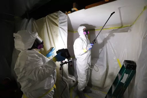 Asbestos Removal Technologies Inc. staff work on asbestos abatement in Howell, Mich., Oct. 18, 2017. The Environmental Protection Agency on Monday, March 18, 2024, announced a comprehensive ban on asbestos, a carcinogen that kills tens of thousands of Americans every year but is still used in some chlorine bleach, brake pads and other products. (AP Photo/Paul Sancya, File)