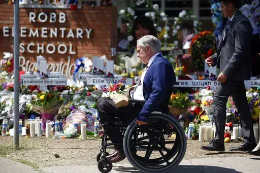 Texas Governor Greg Abbott passes in front of a memorial outside Robb Elementary School to honor the victims killed in a school shooting in Uvalde, Texas, May 29, 2022. Abbott again said on Thursday, July 14, 2022, he was initially misled about the police response to the Uvalde school massacre, calling it "shocking" that newly leaked video of officers hesitating for more than an hour does not match what he had first described to the public as a swift and brave confrontation. (AP Photo/Dario Lope