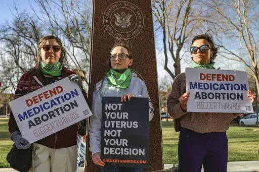 Three members of the Women's March group protest in support of access to abortion medication outside the Federal Courthouse on Wednesday, March 15, 2023 in Amarillo, Texas. (AP Photo/David Erickson, File)