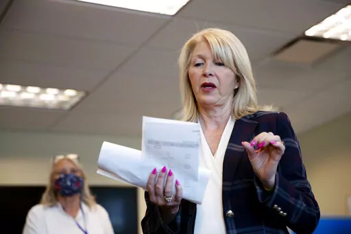 In this June 30, 2020, file photo, Mesa County Clerk Tina Peters reads an update on the election in Grand Junction, Colo. Election officials preparing for this year’s midterm elections have yet another concern to add to an already long list of threats that includes the potential for equipment failures, ransomware or a cyberattack waged by a hostile foreign government. (McKenzie Lange/The Grand Junction Daily Sentinel via AP, File)