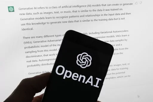 The OpenAI logo is seen on a mobile phone in front of a computer screen displaying output from ChatGPT, March 21, 2023, in Boston. The U.S. Federal Trade Commission has launched an investigation into ChatGPT creator OpenAI and whether the artificial intelligence company violated consumer protection laws by scraping public data and publishing false information through its chatbot, according to reports in the Washington Post and the New York Times. (AP Photo/Michael Dwyer, File)