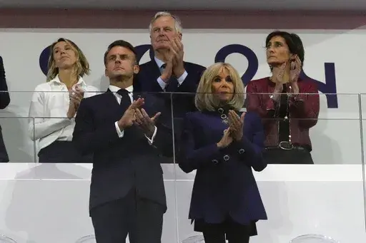 French Prime Minister Michel Barnier, background center, French President Emmanuel Macron, foreground left, and Macron's wife, Brigitte Macron, foreground right, applaud during the closing ceremony of the 2024 Paralympics, Sunday, Sept. 8, 2024, in Paris, France. (AP Photo/Michel Euler, File)
