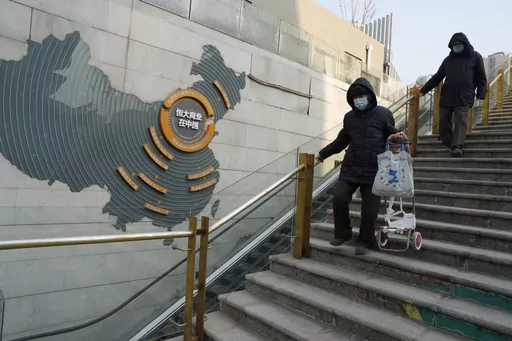 Residents walk through a partially shuttered Evergrande commercial complex in Beijing, Monday, Jan. 29, 2024. Chinese property developer China Evergrande Group on Monday was ordered to liquidate by a Hong Kong court, after the firm was unable to reach a restructuring deal with creditors. (AP Photo/Ng Han Guan)
