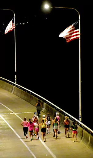 A group of runners cross the Veteran's Bridge as they return to Girls Preparatory School as they take part in  "Finish Eliza's Run" on Friday, Sept. 9, 2022 in Chattanooga, Tenn. The approximately four mile run was to memorialize, Eliza Fletcher, the Memphis runner, and mother of two, who was murdered during her early morning run.   (Robin Rudd /Chattanooga Times Free Press via AP)