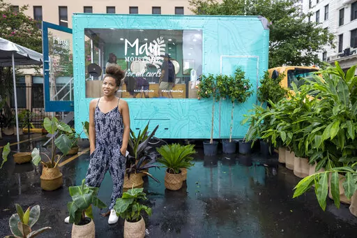 Vanessa Dawson, back left, producer of Maui Moisture, stands in her hair care truck near the Essence Festival in downtown New Orleans on Thursday, June 30, 2022. Essence's chief executive officer said she's been asked a multitude of times whether the Essence Festival of Culture is staying in New Orleans. On Thursday, Caroline Wanga ended any speculation, making the answer to that question very clear.(Chris Granger/The Times-Picayune/The New Orleans Advocate via AP)