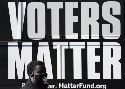 A man wearing a mask gathers with a group in support of Black Voters Matter at the Graham Civic Center polling site in Graham, N.C., Nov. 3, 2020. Some top Democrats are worried that a dip in Black voter turnout, along with other challenges, could doom President Joe Biden and his party in 2024. (AP Photo/Gerry Broome, File)