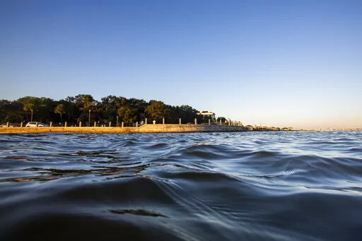 As high tide laps against the sea wall tourist walk down the Battery in Charleston, S.C. Friday, Nov. 13, 2020. According to a U.S. federal report released on Tuesday, Feb. 15, 2022, seas lapping against America’s coastlines are rising ever faster and will be 10 to 12 inches higher by the year 2050 with major U.S. Eastern cities regularly hit with costly sunny day flooding. (AP Photo/Mic Smith, File)