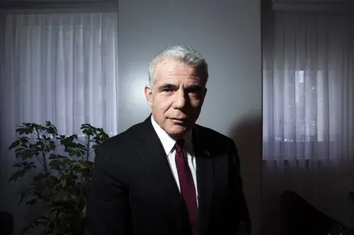 Israel's opposition leader Yair Lapid poses for a photo at his office in Tel Aviv, Israel, Thursday, May 21, 2020. Following the government's decision to dissolve parliament, Lapid, now foreign minister, is set to take office as caretaker prime minister until elections in the fall. It will be a critical test for Lapid, 58, who will try to convince Israelis he is worthy of the top office as he takes on a resurgent Netanyahu. (AP Photo/Oded Balilty, File)