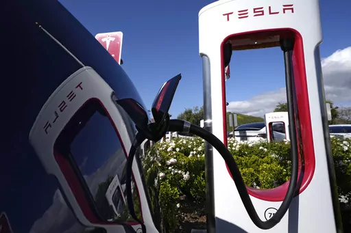 A Tesla auto charges on May 10, 2023, in Westlake, Calif. All of Ford Motor Co.'s current and future electric vehicles will have access to about 12,000 Tesla Supercharger stations starting in 2024, according to an announcement Thursday, May 25, 2023, by Ford CEO Jim Farley and Tesla CEO Elon Musk. (AP Photo/Mark J. Terrill, File)
