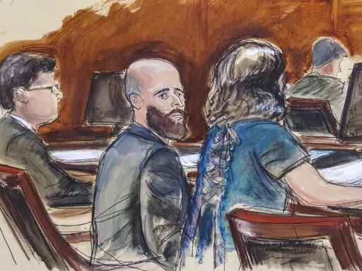 In this courtroom sketch, Joshua Schulte, center, is seated at the defense table flanked by his attorneys during jury deliberations, Wednesday March 4, 2020, in New York. Schulte, the former CIA software engineer accused of causing the biggest theft of classified information in CIA history, has been convicted at a New York City retrial. A jury reached the guilty verdict against Joshua Schulte on Wednesday, July 13, 2022 in federal court in Manhattan. (Elizabeth Williams via AP)