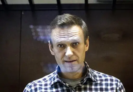 Russian opposition leader Alexei Navalny looks at photographers standing in the Babuskinsky District Court in Moscow, Russia, Saturday, Feb. 20, 2021. Jailed Russian opposition leader Alexey Navalny threw a bombshell Wednesday April 20, 2022 into France's tight and tense presidential election campaign, alleging that Russian leader Vladimir Putin may have bought off French far-right candidate Marine Le Pen with a bank loan. Navalny offered no proof of his allegation, and made it clear he supports