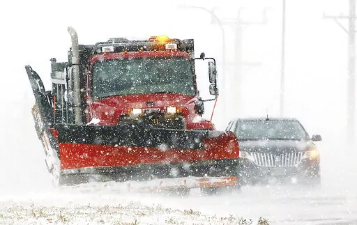 A South Dakota state snow plow clears a shoulder along Highway 50 on the north edge of Yankton, S.D., on Thursday, Dec. 15, 2022, as light snow swept by strong winds reduced visibility to a quarter-mile at times. Yankton is about 200 miles east of the Rosebud Sioux Reservation, which was battered by a mid-December snowstorm that left roads impassable. A 12-year-old asthmatic boy was among six people who died on the reservation during the storm. The tribe says all of the deaths could have been pr