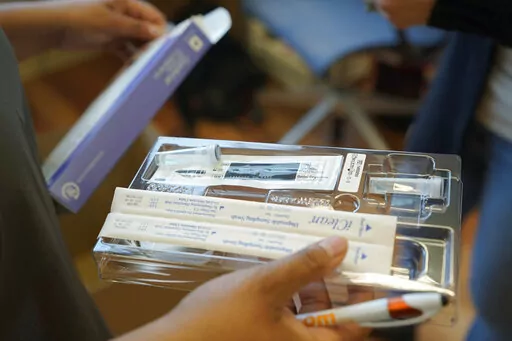 A home COVID-19 test kit is held, Feb. 3, 2022, in Seattle.  Medicare says that millions of enrollees will finally have access to free over-the-counter COVID-19 tests at drug stores. Monday's announcement comes amid worries that the latest coronavirus variant __ BA.2 __ will spark another rise in U.S. cases. (AP Photo/Ted S. Warren, File)
