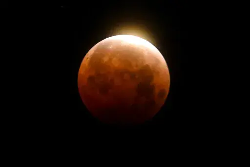 Light shines from a total lunar eclipse over Santa Monica Beach in Santa Monica, Calif., Wednesday, May 26, 2021. A total lunar eclipse will grace the night skies this weekend, providing longer than usual thrills for stargazers across North and South America. The celestial action unfolds Sunday night, May 15, 2022 into early Monday morning, with the moon bathed in the reflected red and orange hues of Earth’s sunsets and sunrises for about 1 1/2 hours, the longest totality of the decade. It wil