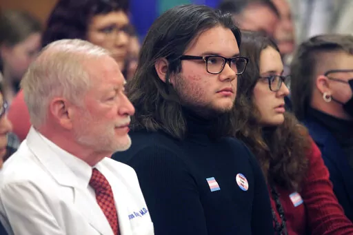 Adam Kellogg, center, a University of Kansas student and transgender man, follows a Kansas Senate health committee hearing on legislation aimed at preventing gender-affirming care for minors, Tuesday, Feb. 14, 2023, at the Statehouse in Topeka, Kan. The Republican-controlled Kansas Legislature is also considering a measure to define male and female in state law in such a way that it could prevent transgender men and women from changing their driver's licenses and birth certificates. (AP Photo/Jo