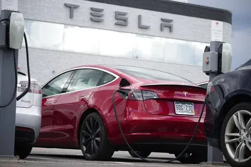 A 2021 Model 3 sedan is connected to a charger at a Tesla dealership on June 27, 2021, in Littleton, Colo. The National Highway Traffic Safety Administration said Thursday, June 9, 2022, that it's upgrading the probe into an engineering analysis, another sign of increased scrutiny of the electric vehicle maker and automated systems that perform at least some driving tasks. (AP Photo/David Zalubowski, File)