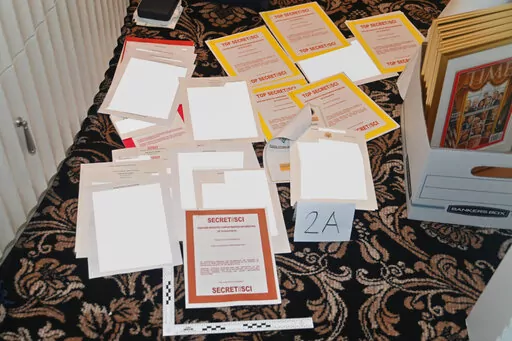 This image contained in a court filing by the Department of Justice on Aug. 30, 2022, and partially redacted by the source, shows a photo of documents seized during the Aug. 8 FBI search of former President Donald Trump's Mar-a-Lago estate. Lawyers for fTrump have in recent months turned over to federal investigators additional documents with classified markings as well as a laptop belonging to a Trump aide.(Department of Justice via AP, File)
