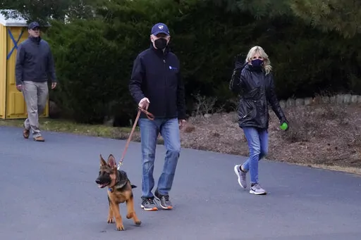 President Joe Biden and first lady Jill Biden take their dog Commander for a walk in Rehoboth Beach, Del., Tuesday, Dec. 28, 2021. (AP Photo/Patrick Semansky)