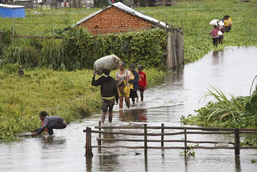 Residents wade through flood water around their homes after heavy rain in Antananarivo, on Jan. 19, 2022. Rich countries say they will spend about $25 billion by 2025 to boost Africa’s efforts to adapt to climate change as the continent continues to struggle with drought, cyclones and extreme heat, according to officials at a summit in Rotterdam in the Netherlands. (AP Photo/Alexander Joe, File)