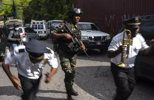 Police escort musicians arriving for the swearing-in ceremony of a transitional council tasked with selecting a new prime minister and cabinet at the Prime Minister's office in Port-au-Prince, Haiti, Thursday, April 25, 2024. (AP Photo/Ramon Espinosa)