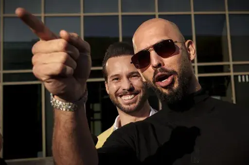Andrew Tate gestures, next to his brother, Tristan, outside the Bucharest Tribunal in Bucharest, Romania, Thursday, Jan. 9, 2025. (AP Photo/Vadim Ghirda, File)