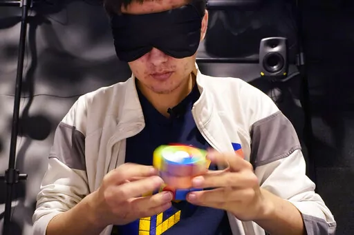 University of Michigan student Stanley Chapel solves a Rubik's Cube while blindfolded, Wednesday, Nov. 23, 2022, in Ann Arbor, Mich. Stanley is one of the world's foremost "speedcubers," a person capable of quickly solving a Rubik's Cube. He also is an accomplished violinist. Chapel says the two fields aren't as different as one might think. Chapel has certain inherent abilities -- he is capable of remembering and applying thousands of algorithms to solve a Rubik's Cube and performing one of Joh
